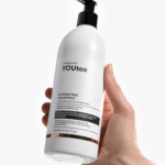 Женская рука держит флакон шампуня YOUtoo Hydrating Shampoo 500 мл — YOUtoo