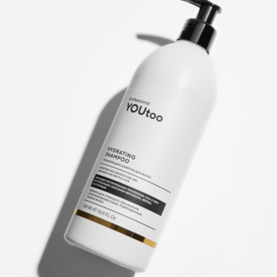 Флакон шампуня YOUtoo Hydrating Shampoo 500 мл лёжа на светлой поверхности с тенью — YOUtoo