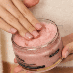 Руки держат открытую банку розового сахарного скраба HONEY ROSE YOUtoo — YOUtoo