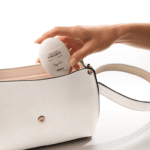 Рука вынимает белый флакон крема для рук YOUtoo Cherry in Love из белой сумки — YOUtoo