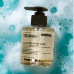 Парфюмированное жидкое мыло YOUtoo Caramel Ecstasy в прозрачном флаконе с дозатором на фоне мыльных пузырей — YOUtoo