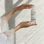 Женские руки держат флакон пенки для умывания YOUtoo в лучах света — YOUtoo