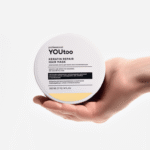 Женская рука держит открытую банку кератиновой маски YOUtoo Keratin Repair 300 мл — YOUtoo