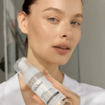 Девушка держит прозрачный флакон успокаивающей пенки для умывания YOUtoo — YOUtoo