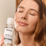 Девушка держит флакон мицеллярной воды YOUtoo Calming у лица с закрытыми глазами — YOUtoo