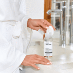 Руки нажимают на дозатор флакона мицеллярной воды YOUtoo над раковиной — YOUtoo