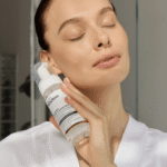 Девушка держит флакон успокаивающей пенки для умывания YOUtoo у лица — YOUtoo