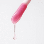 Капля розового масла GLAZE ME! стекает с пипетки — текстура масла-блеска для губ — YOUtoo