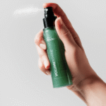 Рука распыляет зелёный флакон-спрей YOUtoo Volume & Shine — YOUtoo